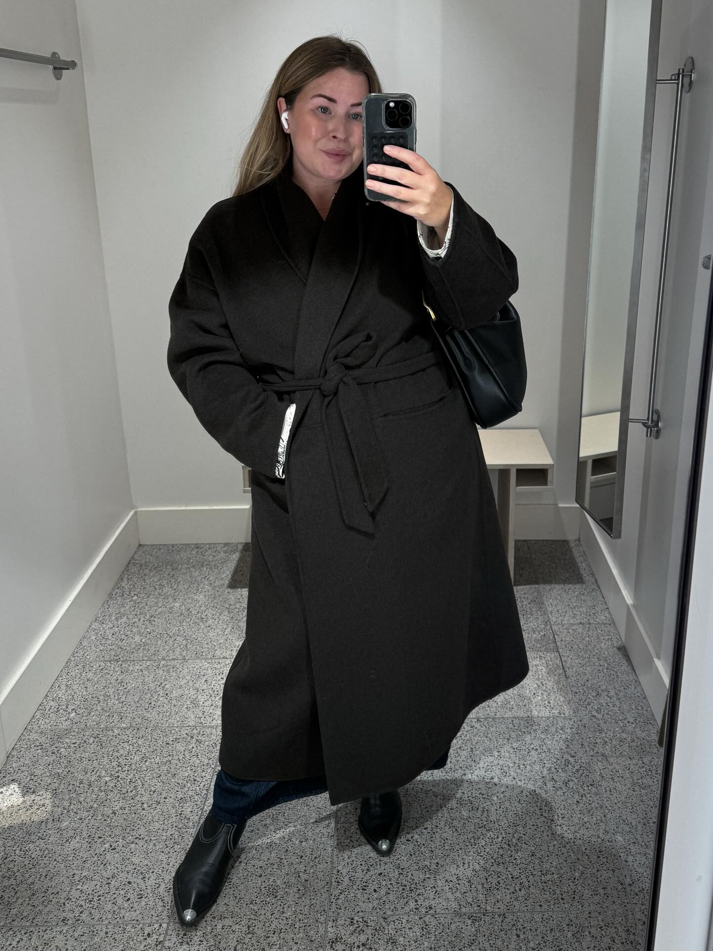 A Belted Black Coat with Denim for Streamlined Cold-Weather Style
